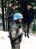 A Dutch UN peacekeeper standing near two unidentified Bosnian men in Srebrenica in 1994.